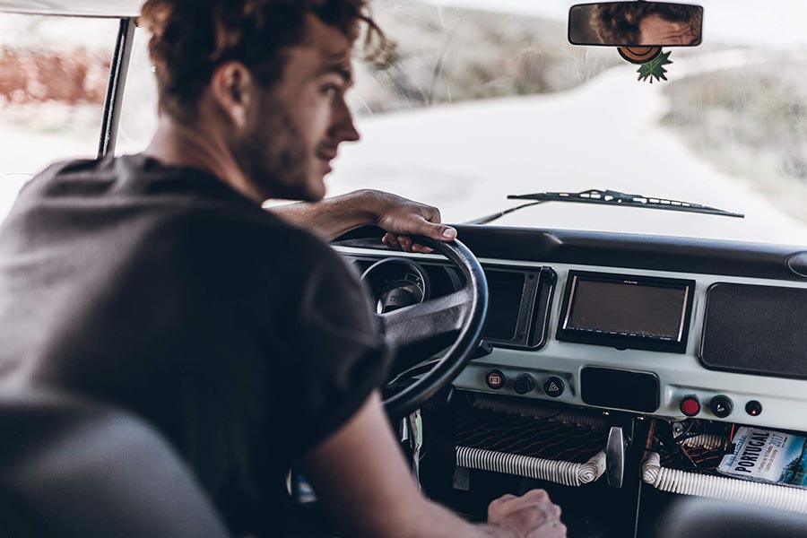 Man driving a hired vintage VW campervan in Portugal.