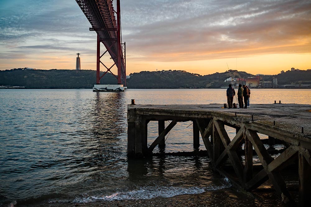 Sunset in Alcantara with Cristo Rei and Ponte 25 de Abril bridge.