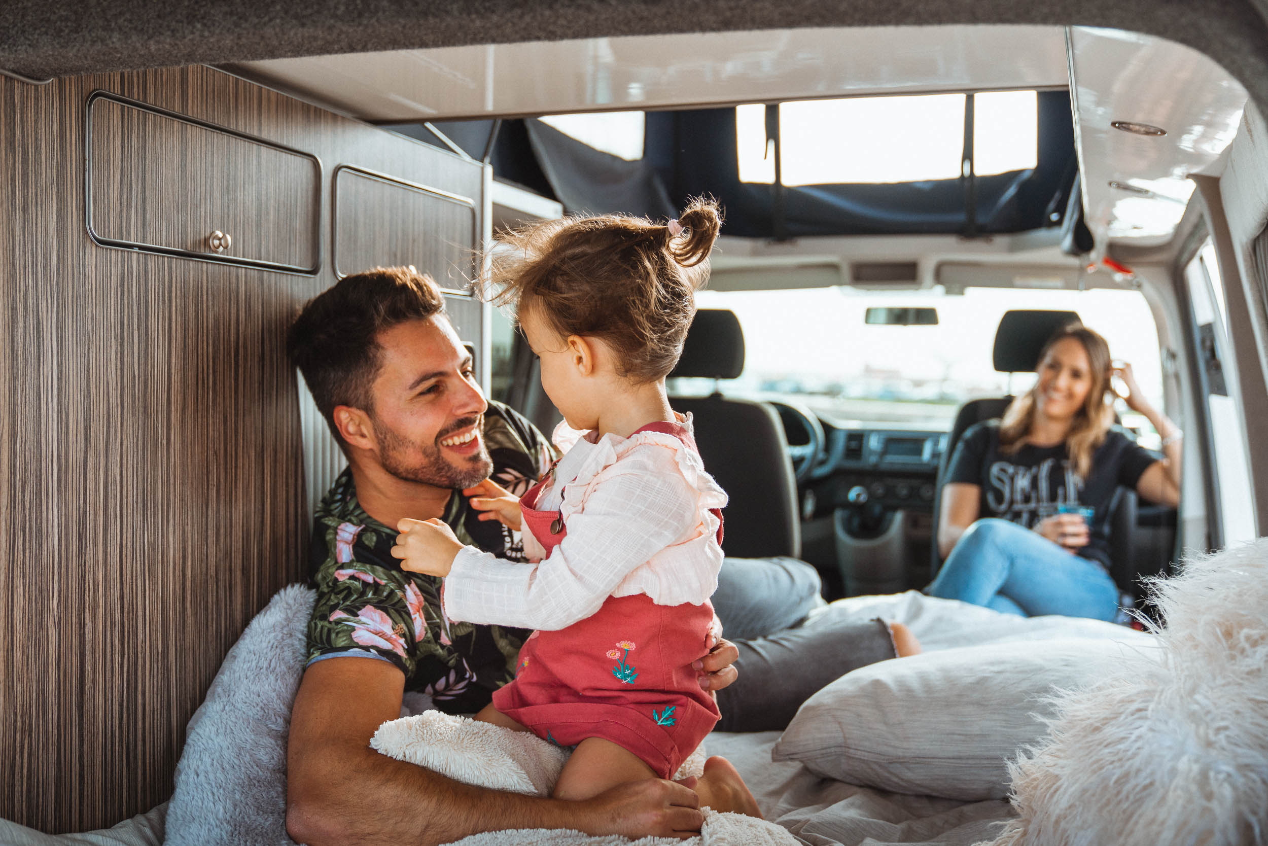 Eltem mit einem kleinen Kind, das im Inneren des Siesta Campers VW T6 Campers spielt.