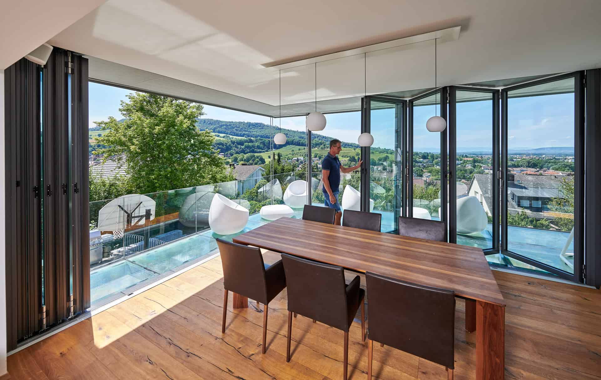 wood aesthetic dining area with open bifolds and sunny views