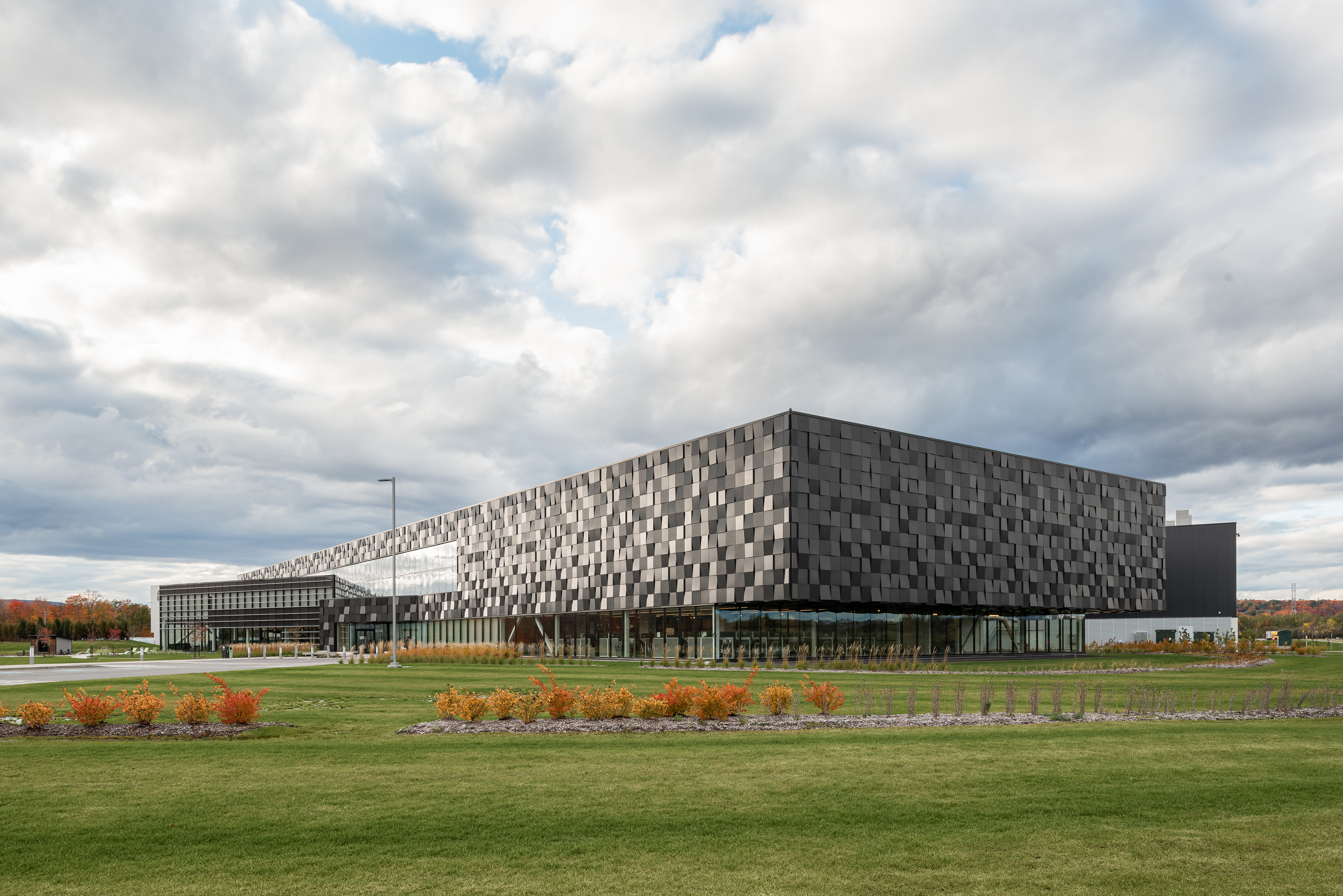Photographie de l'architecture d'un très grand centre de distribution commercial à Quebec. Les facettes de la façade reflètent la lumière naturelle.