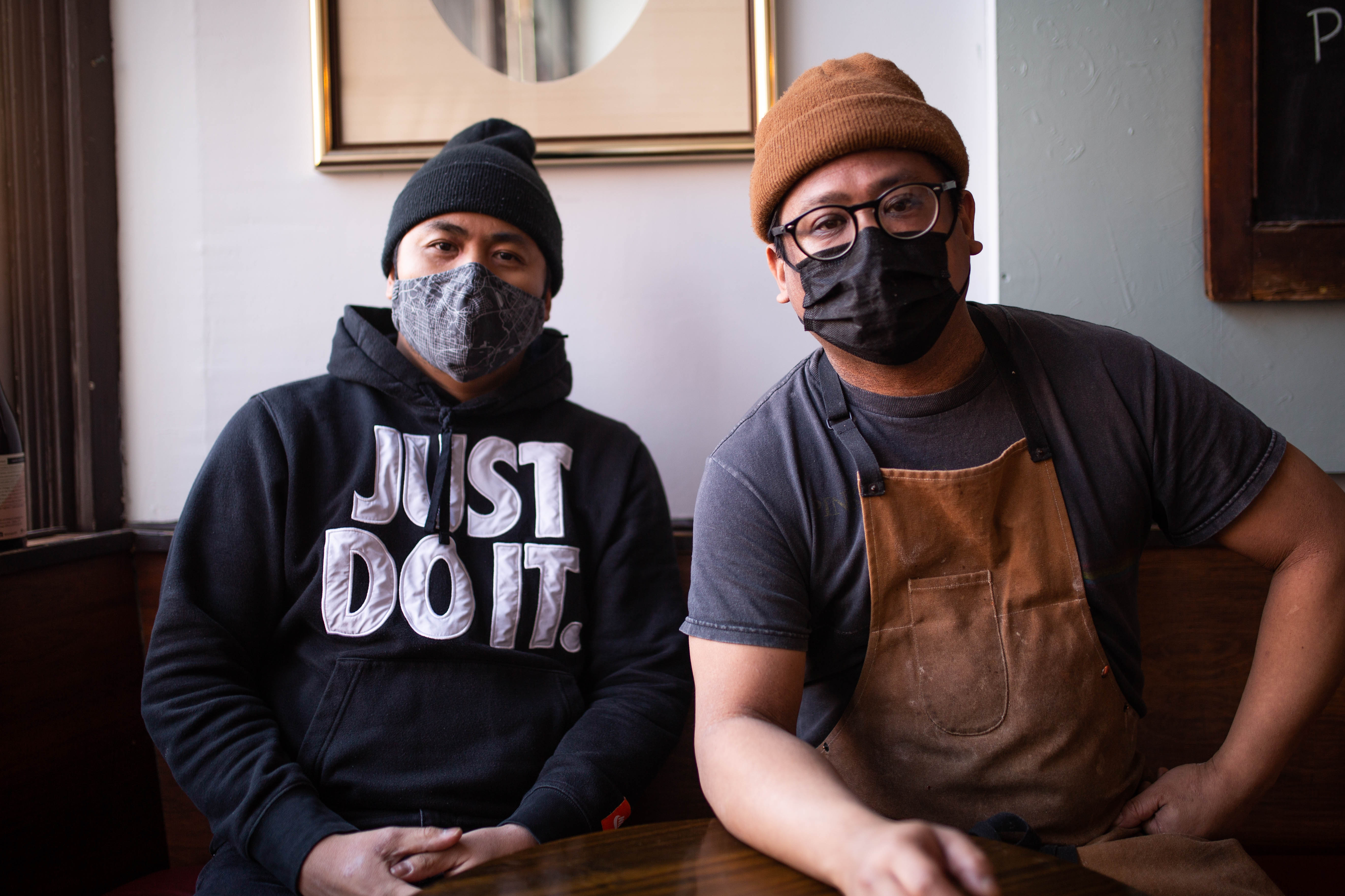 Chuck Ortiz (left) and Sean Santos (right) sit in the dining room of their restaurant Saints Island Pies in Brockton Village.
