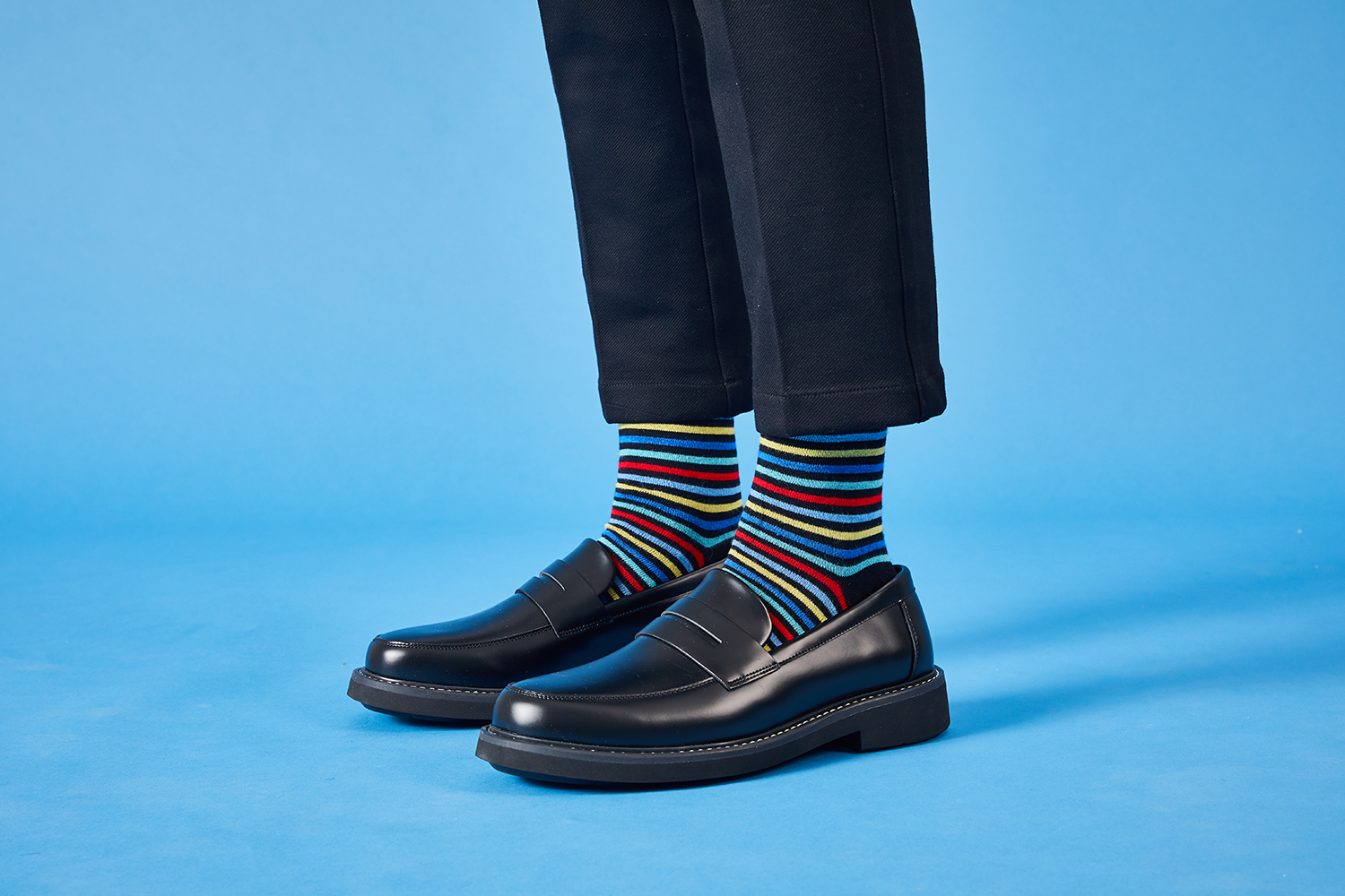 person wearing striped socks and black shoes