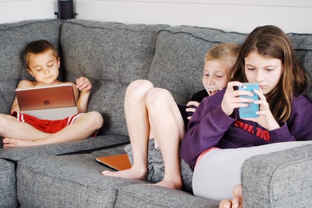 Children playing games on mobile phones and laptops