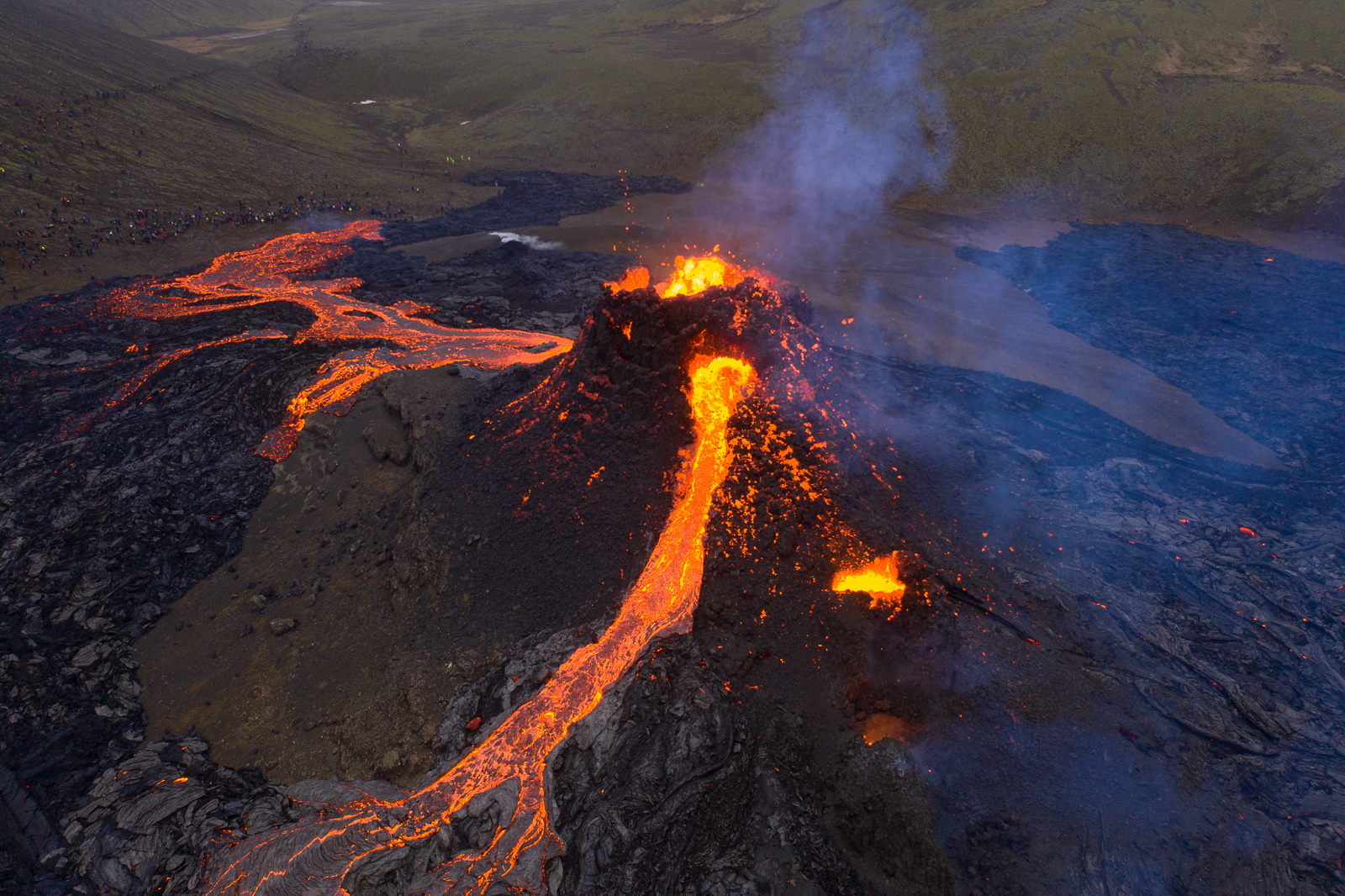 Red hot lava rivers flowing from a volcanic crater