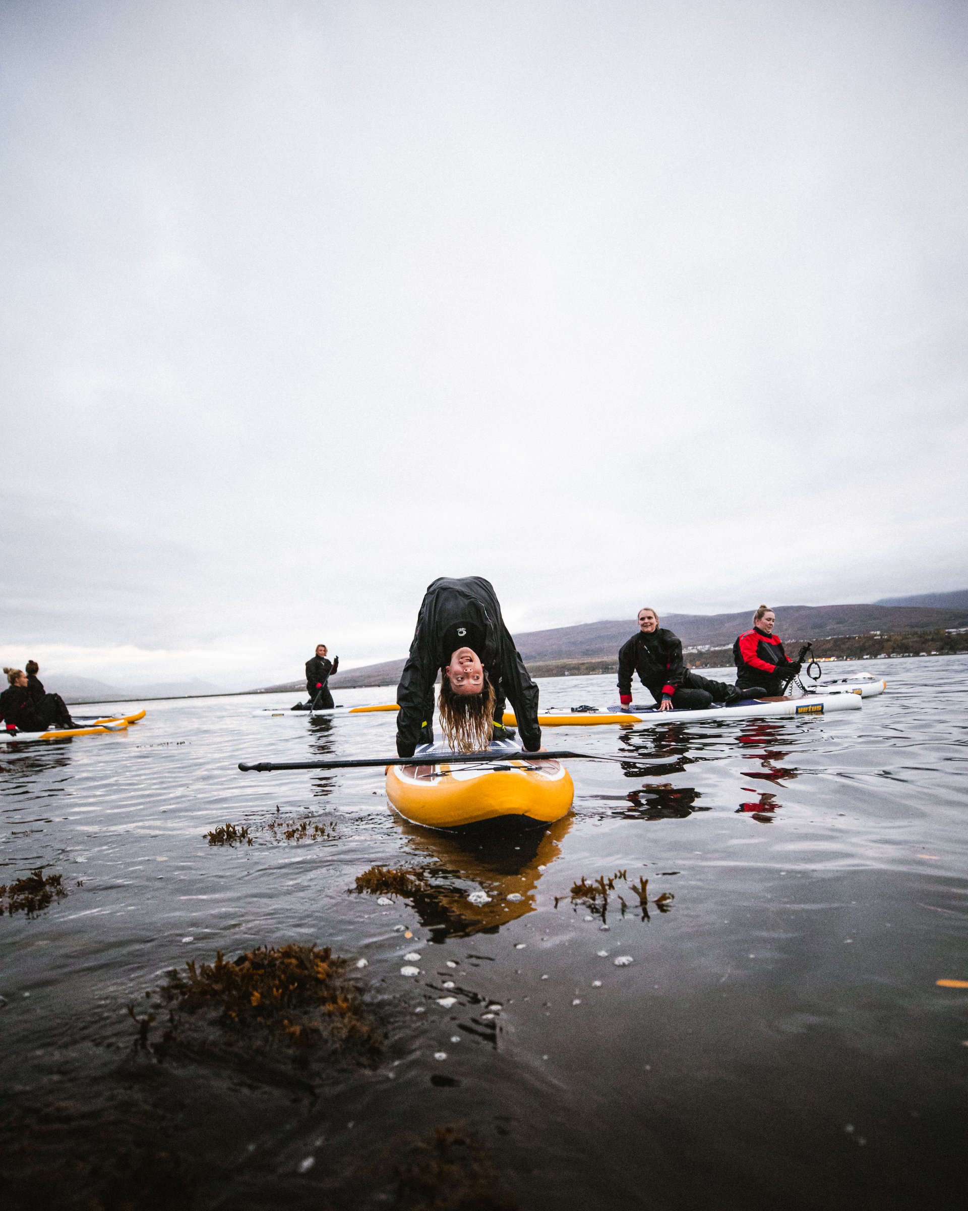 woman doing yoga on a stand up paddle board