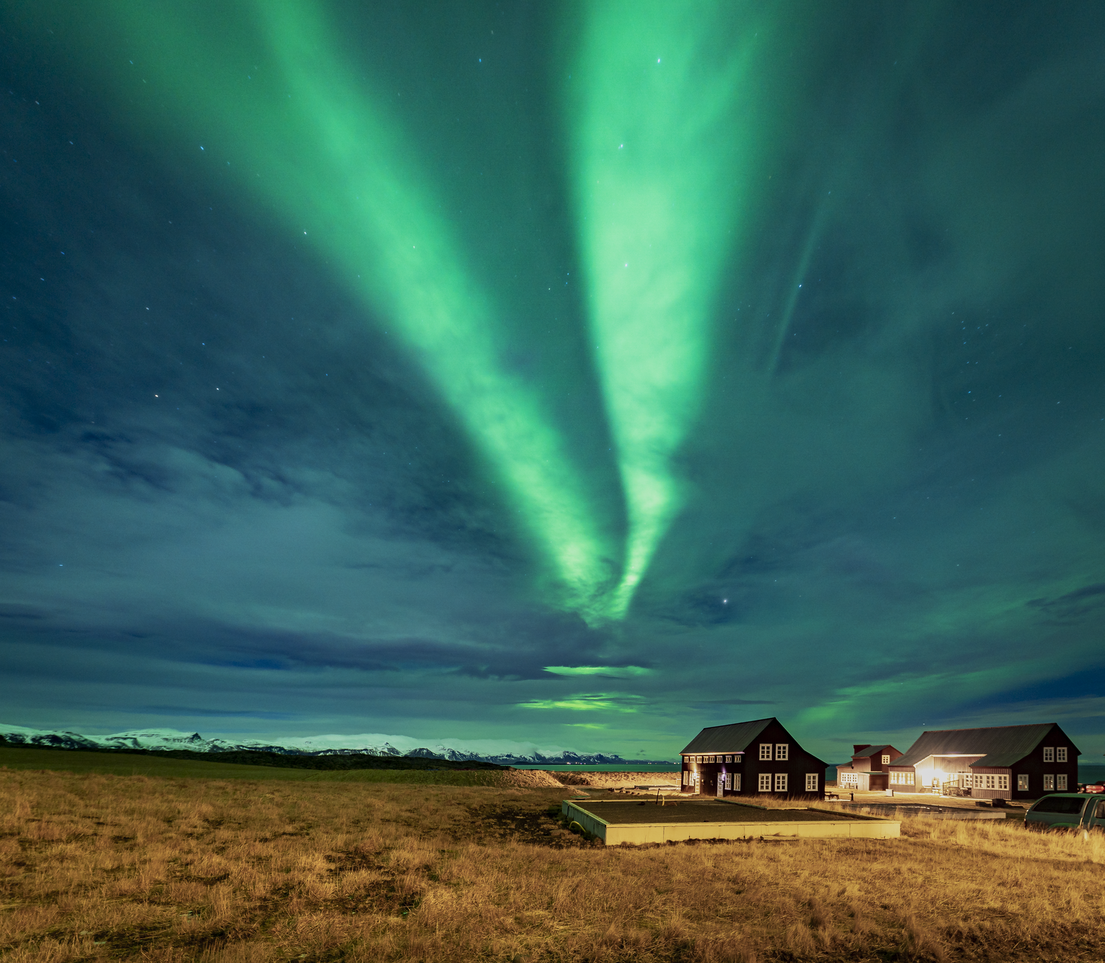 Northern lights over houses in West Iceland