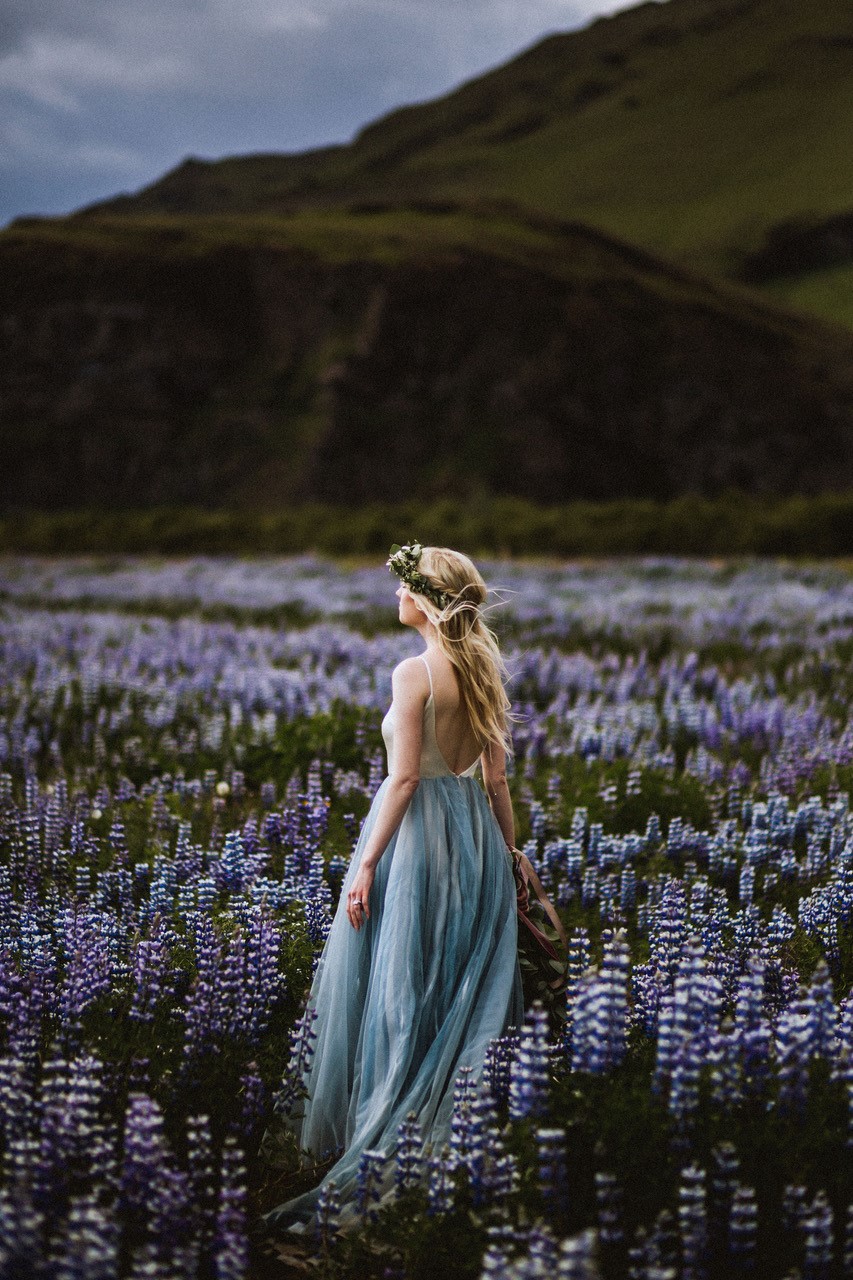 Woman walking in a field of lupines