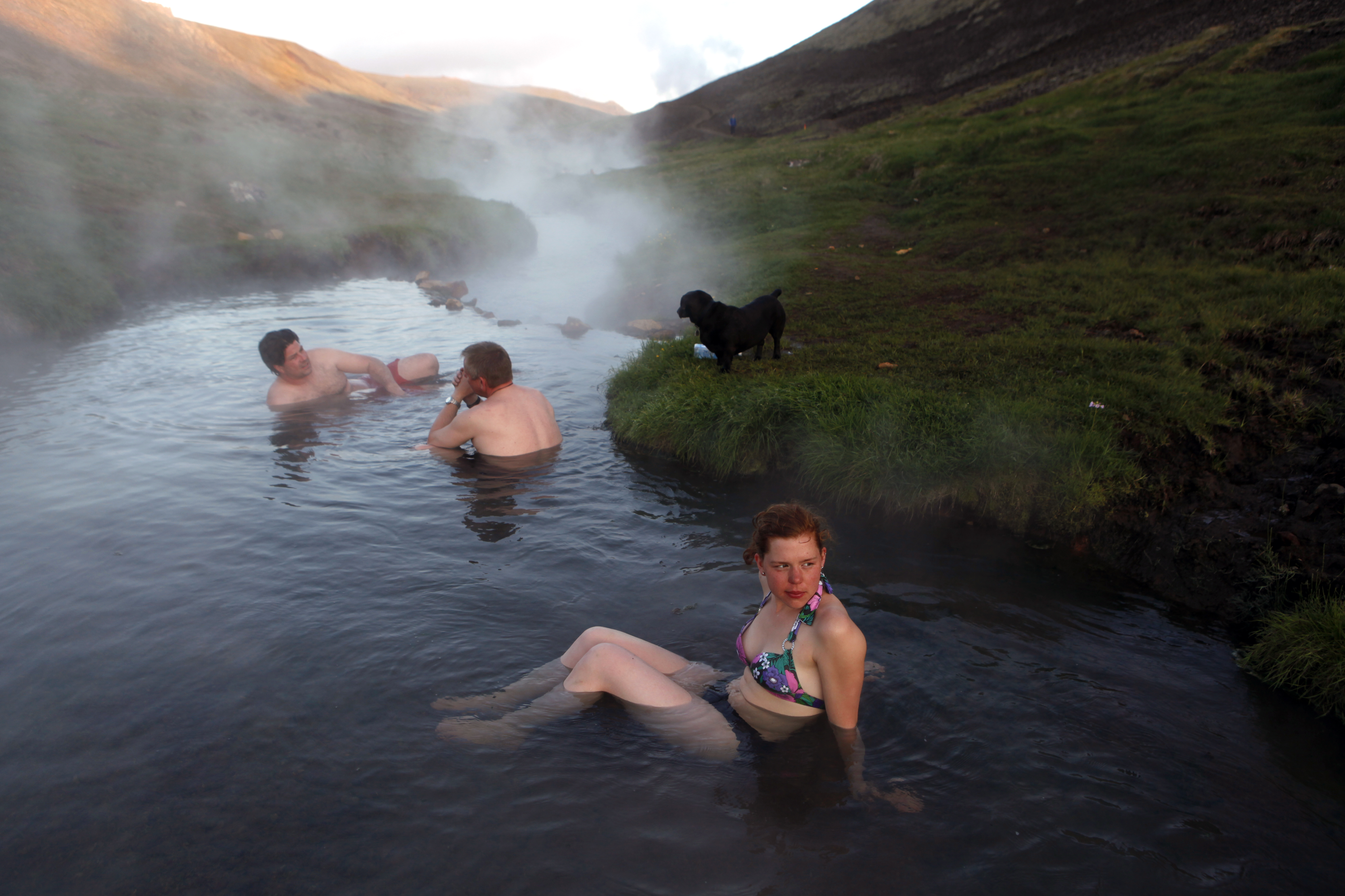 People soaking in a hot river in Hveragerði, Iceland