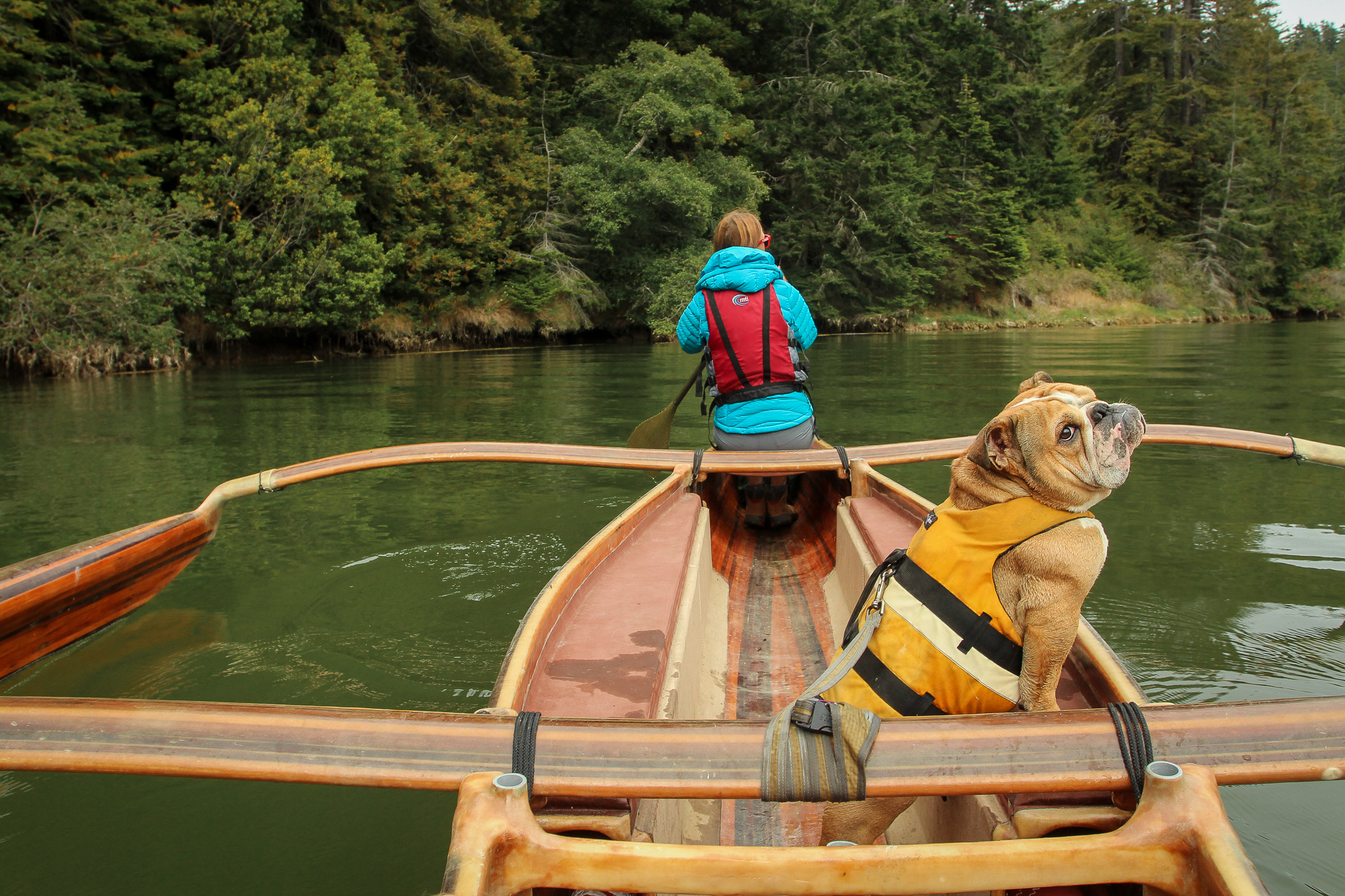 Woman and her dog on a canoe on the Big River in Mendocino 