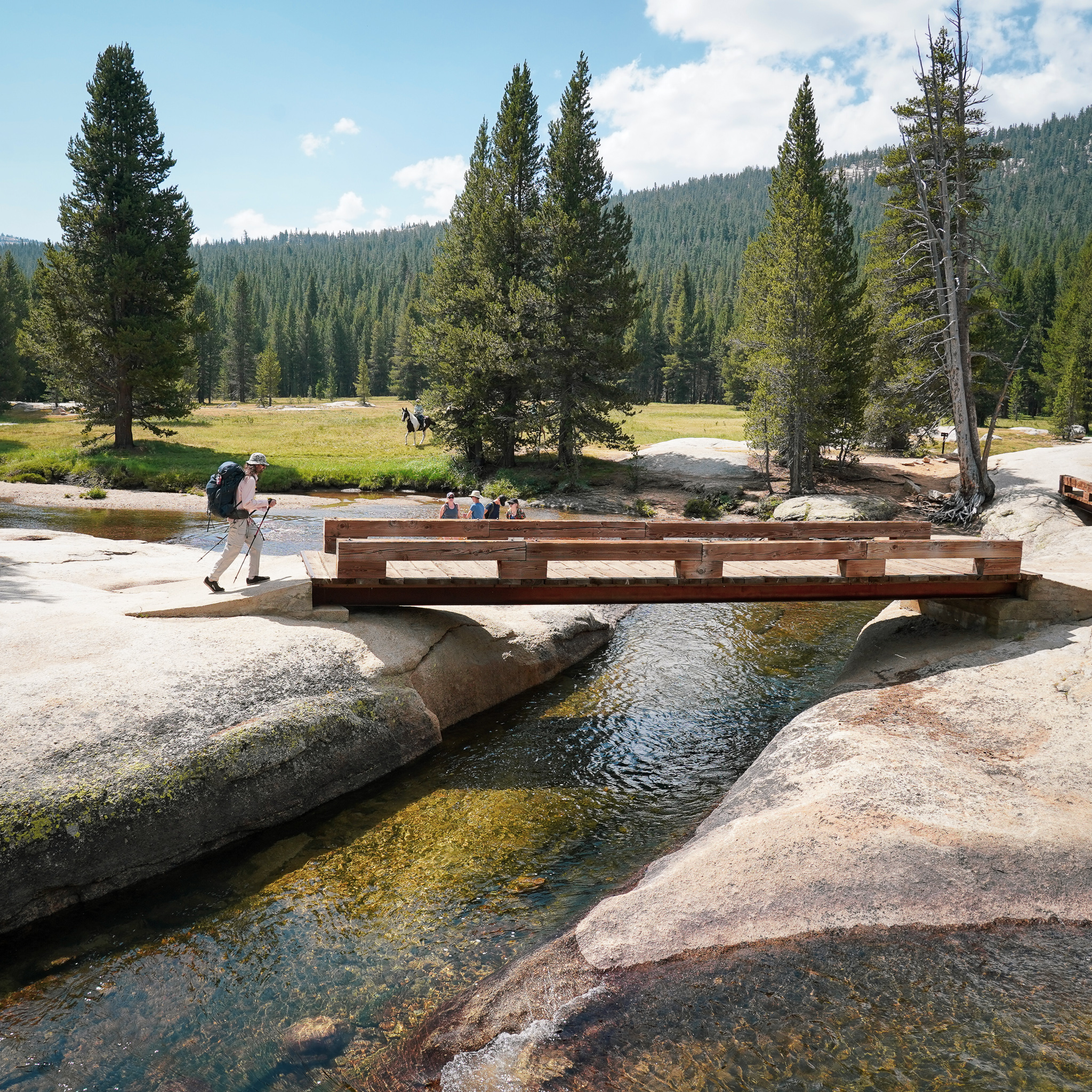 hiker crossing Lyell Fork of Tuolumne River in Yosemite