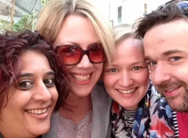 Photograph of four people smiling for the camera