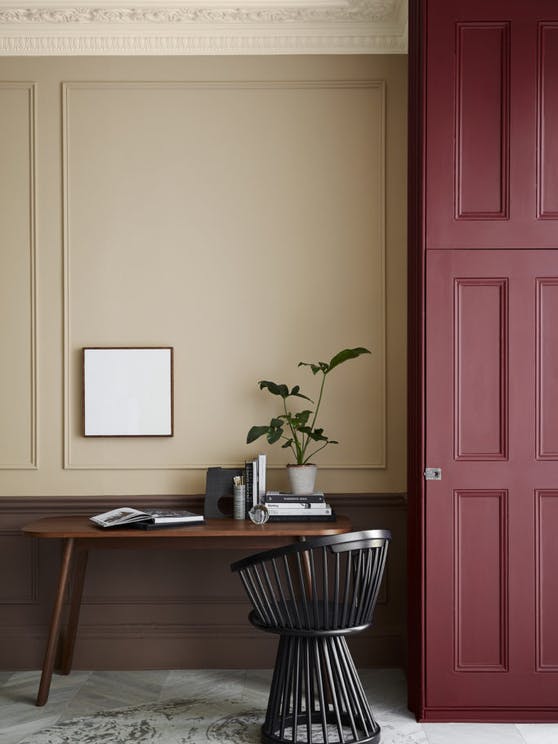 Warm neutral (Castell Pink) home study area with a red (Arras) door next to a wooden desk and chair.